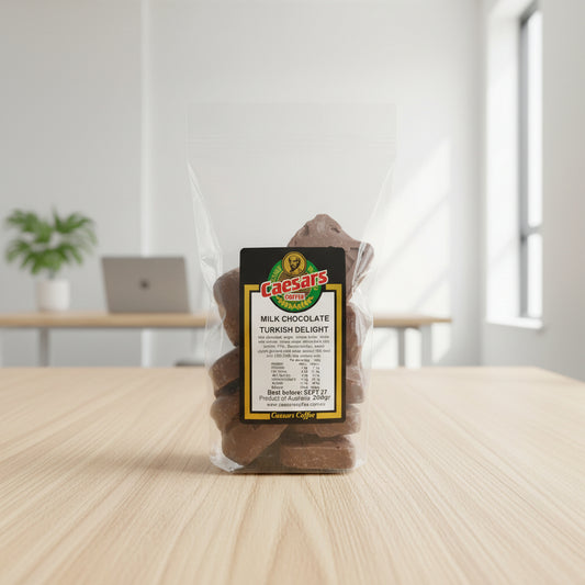 A clear plastic bag containing pieces of Caesars Coffee's Milk Chocolate Turkish Delight, with a black and gold label featuring the red and green Caesars Coffee logo, packed in a 200g cello bag.